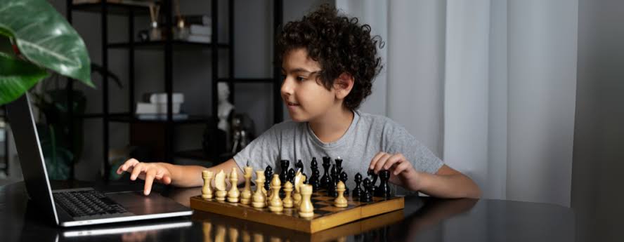 Young child concentrating on a chess move during a live online chess class