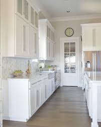 Creating a focal point at the end of a galley kitchen is a powerful design tool that draws the eye, making a small space feel longer and larger. Gorgeous White Kitchen With White Carrara Marble And White Cabinets Http Www Zdesignatho Galley Kitchen Design Kitchen Cabinet Remodel Galley Kitchen Remodel