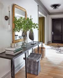 Typically, it is a small hallway or open space just behind the main entrance that acts as a reception area for guests. The Entryway In This Calgary Home Showcases Soft Industrial Edge With Pieces Like The Cast Iron Console Table A Entry Furniture Foyer Decorating House Interior