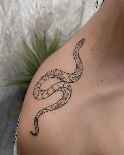 Line art snake tattoo on the top of the shoulder.