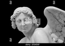 Angel ali isolate su sfondo nero con copyspace. Statua di cherubino da  vicino Foto stock