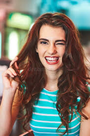 Faccia Da Occhiolino E Ritratto Di Bellezza Di Una Donna in Studio Con  Trucco Da Sorriso E Mani Nei Capelli. La Testa Di Una Donna Immagine Stock 
