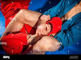 Man wrestlers of grappling and jiu jitsu in a blue and red kimono makes submission  wrestling.Fighting techniques: armbar, armlock Stock Photo - Alamy