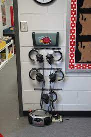Simple Headphone Storage Solutions Organized Classroom Wooden curved holders bear their owner's names in block.
