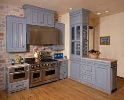 The cabinets are all painted in a matte steel blue color, which contrasts well with the white tile backsplash and warm color of the solid teak wood flooring. Beautiful Blue Kitchen Design Ideas