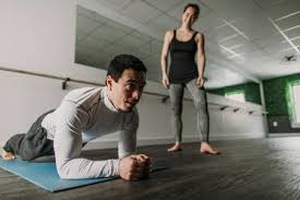 However, i'm proud to say my greatest results came while training with archie!!! Man Does Plank While His Female Personal Trainer Coaches In Background Stockphoto
