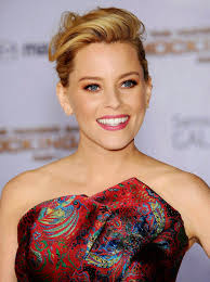 She is first introduced in the first book and film and appears to be very posh like many other capitol residents. Elizabeth Banks The Hunger Games Mockingjay Part 1 Premiere In Los Angeles Elizabeth Banks Strapless Paisley