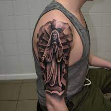 Most virgin mary tattoos are done in muted black and grey ink. Black And Grey Virgin Mary Tattoo On The Upper Arm