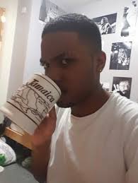 Handsome black man drinking coffee or tea with strong eye contact