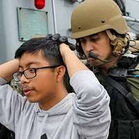 Chief Petty Officer Jeffrey T. Elwood, center, explains