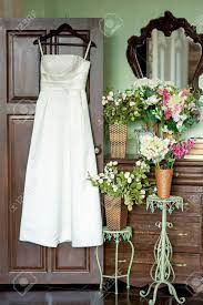 Wählen sie aus illustrationen zum thema hochzeitskleid von istock. Das Hochzeitskleid Auf Einem Bugel Hangt An Einer Tur In Der Nahe Einer Alten Kommode Und Blumen Lizenzfreie Fotos Bilder Und Stock Fotografie Image 46810753