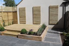A Paved Terrace With Raised Planters Using Sleepers Decked Steps Then Lead To A Decked Softwood Patio Garden Design Outdoor Gardens Design Back Garden Design