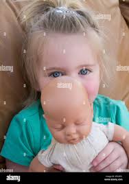 Toddler playing with dolly Stock Photo