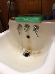 stained bathroom sink with faucet that