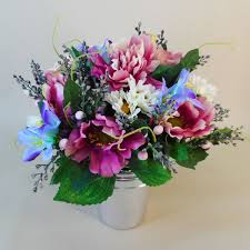 While they will definitely last longer, the elements eventually will cause artificial flowers to fade and become tattered. Silk Flowers Filled Grave Pot Purple Pink And Blue Memorial Flowers