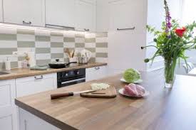 Handless white gloss doors on kitchen and light grey gloss doors on island and tall cabinetry. House Of Worktops Solid Wood Kitchen Worktops In Uk