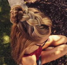 Blonde hair styled in a small, low bun with braided pleats running sideways and curly fringes hanging along the cheeks. 45 Pretty Ideas For Casual And Formal Bun Hairstyles