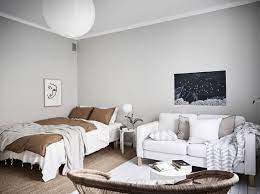 Light grey painted floorboards, soft linen grey bedding and the galvanized metal tub being used as a side table all give this bedroom a lovely modern rustic charm. Bright Studio Apartment In Grey With Warm Accents Studio Apartment Grey Painted Walls Light Grey Painted Walls