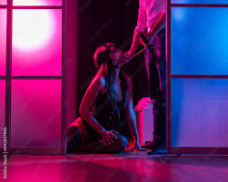 A woman is kneeling in front of a man. BDSM sex concept. Vertical photo. ,  obrazy, fototapety, plakaty - BajeczneObrazy.pl