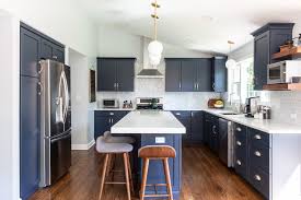 In this 1970s inspired cooking space by architecture and interior design practice atticus & milo, a kitchen island and upper cabinets both in yellow offset the dark walls. Design Trend Blue Kitchen Cabinets