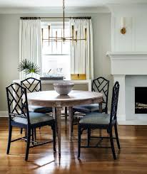 Black Rattan Style Dining Chairs Wood Round Dining Table Brass Chandelier Fireplace In The Di Boho Dining Room Rattan Dining Chairs Dining Room Interiors