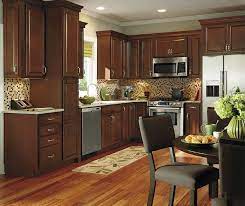 Dark kitchen cabinets and countertops with white backsplash. Dark Wood Kitchen Cabinets Aristokraft Cabinetry