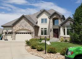 A harge stone house with whit spots and a window. Paint Denver Large Stone House After2 Paint Denver Painting Company