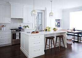 Well Appointed White Kitchen Boasts White And Silver Pendant Lights Hung Over A White Islan White Kitchen White Kitchen Pendant Lights White Kitchen Remodeling
