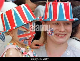 Amy, âgée de 3 ans, et sa mère Louise Shepard avec des drapeaux Union Jack  peints sur leurs visages, attendent parmi la foule à Windsor avant le  mariage royal entre Prince Edward