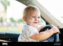 Cute Little Baby Boy Driving Big Car Holding Steering Wheel Smiling And Looking Forward With Interest Childhood Game And Dreams Stock Photo Alamy