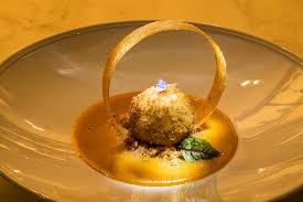 Closeup black plate with fine dining dessert against white. Chef Manish Mehrotra Is On A Mission To Elevate Indian Cuisine For Fine Dining