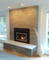 The fireplace boasts a streamlined silhouette embellished with a geometric motif and topped with a blonde wood mantel. 19 Stylish Fireplace Tile Ideas For Your Fireplace Surround