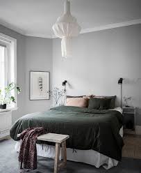 Blue and gray abstract art is mounted over a green dresser that boasts black vases and brass pulls. Cozy Bedroom In Green And Grey Coco Lapine Design Cozy Bedroom Bedroom Decor Cozy Rustic Bedroom