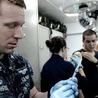 Hospital Corpsman Chief Robert Bott administers a flu mist nasal spray  vaccine to Utilitiesman 3rd Class Anthony Mezlak during a battalion-wide  immunization day at Port Hueneme.