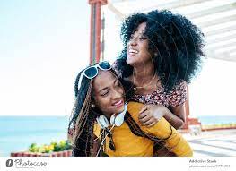 Black female friends having fun on embankment in summer - a Royalty Free  Stock Photo from Photocase