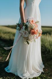 It's the quintessential bridal look. Woman Wearing White Wedding Dress Holding Flower Bouquet Standing On Green Field Free Stock Photo