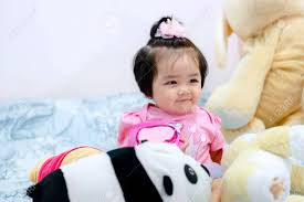 1 Year Old Cute Baby Girl In A Pink Dress Is Playing With Teddy Bear On The Bed In Bangkok Thailand Stock Photo Picture And Royalty Free Image Image 143339029