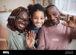 POV shot of happy African-American family smiling at camera while taking  selfie-photo at home or using video chat Stock Photo - Alamy