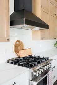 Under cabinet range hoods are available in sizes ranging from 30 to 48, with a cfm of 180 to 1500, so you're sure to find the range hood that fits the. White And Brown Kitchen Cabinets With Black Range Hood Transitional Kitchen