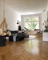 Wohnzimmer Brauner Hangesessel Schwarzes Sofa Grauer Sessel Fischgratenparkett Wohnung Haus Deko Einrichtungsstil