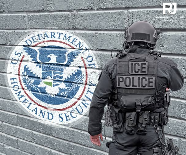 Airport security and immigration enforcement officers inside a terminal.