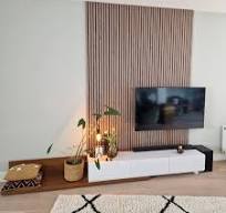 Lattenwand achter de tv gemaakt van houten wandpanelen
