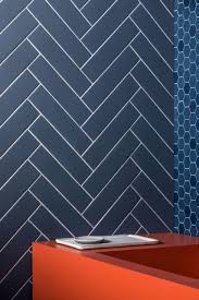 Black and gray vestibule features black and glass doors over thin slate gray herringbone floor tiles lit by a brass star flush mount light. Herringbone Tile Inspiration Mandarin Stone