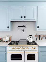 Light, airy kitchen with white cabinets and abundant natural light boasting seeded glass light s over an island with a cooktop and white quartz counters. 53 Blue Kitchens Blue Kitchen Design Ideas Hgtv