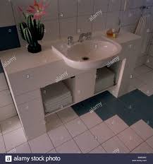 white basin in vanity unit with towels