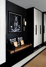 Un Hall D Entree Noir Et Blanc Aux Accents Deco Ethniques Chic Avec Une Belle Assise En Cuir A Cote Du Deco Entree Maison Idee Hall D Entree Idee Deco Couloir