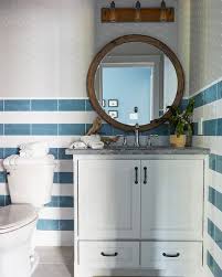 Contemporary kid's bathroom features black and white marble stripe floors which seamlessly continues to the walk in shower. White And Blue Striped Wall Tiles With Round Wood Mirror Cottage Bathroom