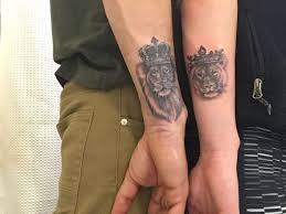 Male And Female Lion Both Wearing Crowns Matching Couple Tattoos Done With Black Ink On The Lower Part O Female Lion Tattoo Matching Tattoos Couple Tattoos
