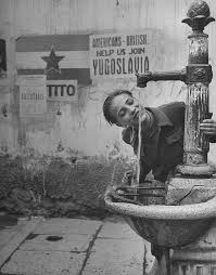 Young boy getting a drink from a water fountain, Yugoslavia, probably  Belgrade, May 1946 [802x1024] : rHistoryPorn