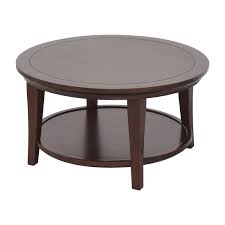 It was printed with a repeating image that might have been a rustic barn with a wagon wheel perched outside or an old mill with a water wheel, surrounded by reddish orange and gold flowers, and possibly wild fowl like pheasants or turkeys. 59 Off Pottery Barn Pottery Barn Metropolitan Round Coffee Table Tables